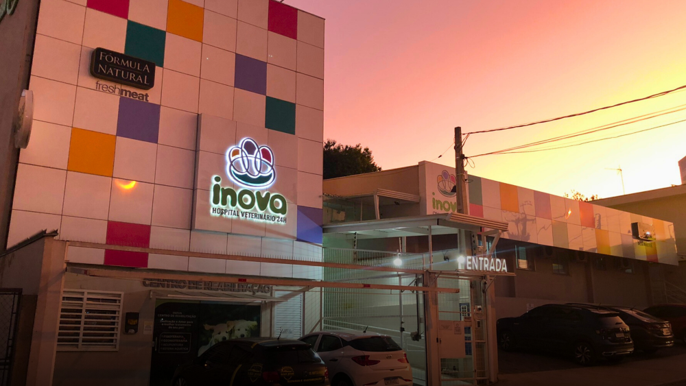 Fachada do Hospital Veterinário Inova em Sorocaba ao entardecer, com design moderno, letreiro iluminado e estacionamento acessível.