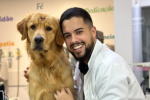 Veterinário do Inova Hospital Veterinário 24h sorrindo ao lado de um Golden Retriever durante atendimento clínico, demonstrando cuidado humanizado com o pet.