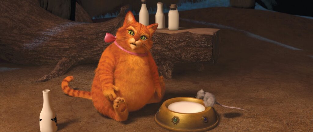 Gato de Botas, personagem de Shrek, aparece acima do peso sentado ao lado de uma tigela.